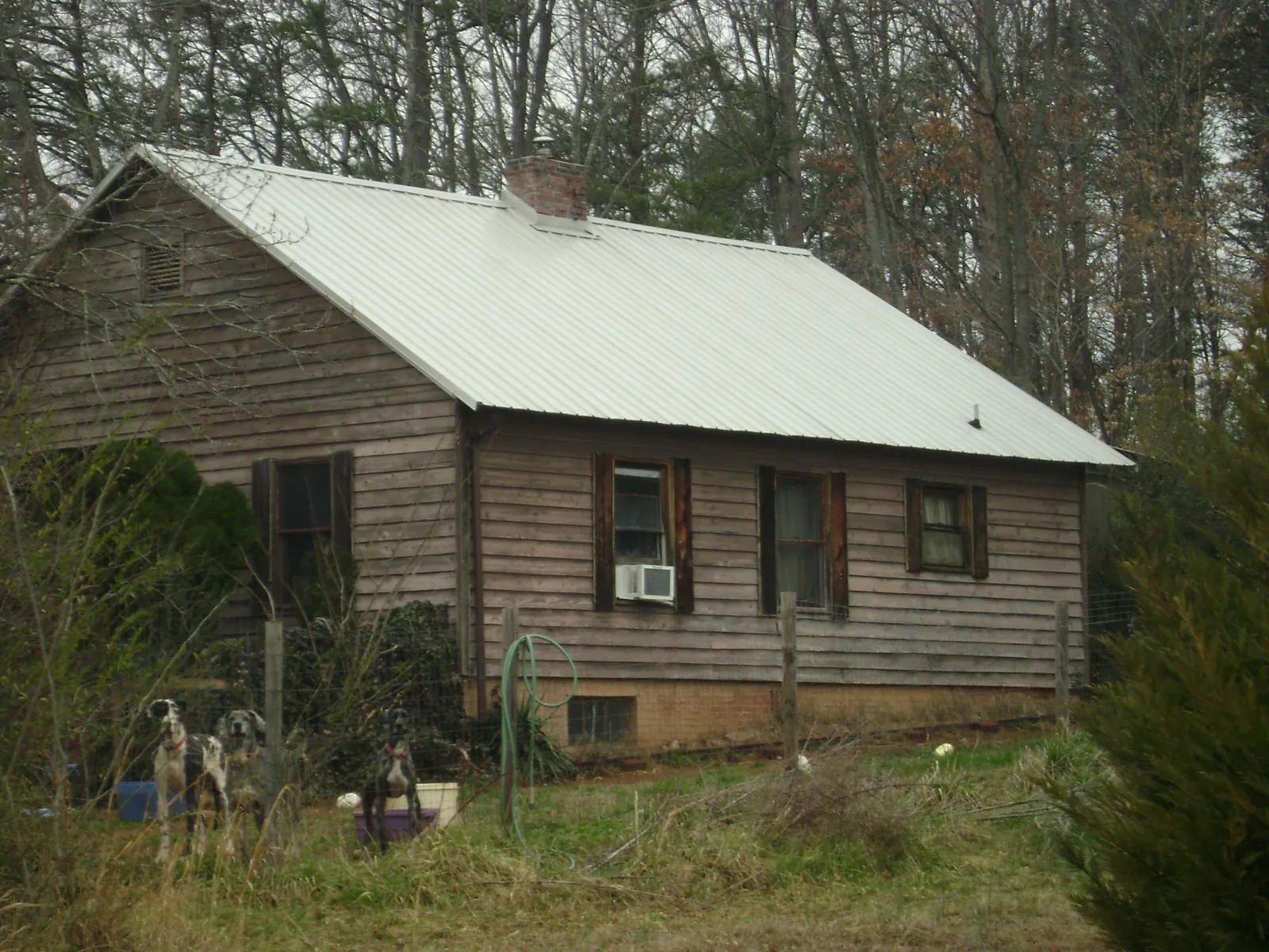 White metal roof on an old wood sided farmhouse, from a Metal Roof Installation job in Highland Park